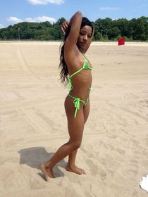 Little curvy ebony Aniya in a bikini posing on the sea beach