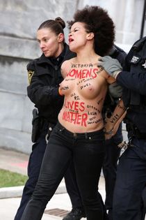 Police taking away a protestor - topless Nicole Rochelle pic